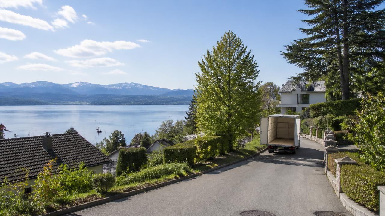 Umzugswagen auf einer Wohnstraße oberhalb des Starnberger Sees mit Blick auf die Alpen
